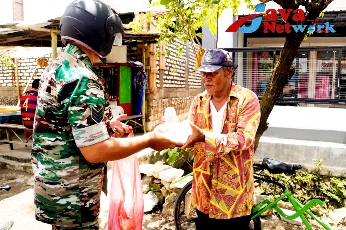 Babinsa Koramil 0827/01 Sumenep Serda Widodo Saat Memberikan Jum'at Berbagi