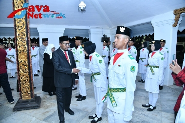 Bupati Sumenep Achmad Fauzi Wongsojudo, SH, MH Saat Memasang Kendit Kepada Salah Satu Anggota Paskibraka di Pendopo Agung Keraton Sumenep, Selasa (15/08/2023) malam