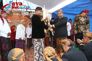 Bupati Sumenep Achmad Fauzi Wongsojudo, SH, MH Saat Menyerahkan Pataka Kepada Kades Torbang Ahmad Muzanni Tandai Prosesi Ritual Tatorbhengen di Desa Torbang Kecamatan Batuan, Jum'at (08/09/2023).