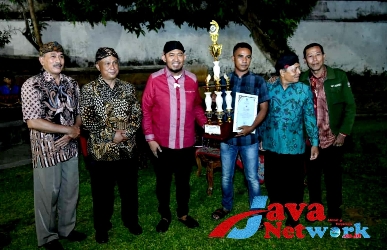 Bupati Sumenep Achmad Fauzi Wongsojudo, SH, MH didampingi Kadisbudporapar Sumenep Moh Iksan, SPd, MT Menyerahkan Piagam Dan Piala Kepada Grup Musik Tong-Tong Angin Ribut Dari Pasongsongan Sebagai Juara Umum Festival Tong-Tong se-Madura 2023, Senin (19/11/2023)