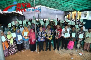 Foto Bersama Bupati Sumenep DR. H. Achmad Fauzi Wongsojudo, SH, MH usai menyerahkan Sertifikat Tanah Program PTSL di Desa Bun Barat Kecamatan Rubaru, Kamis (04/01/2024)