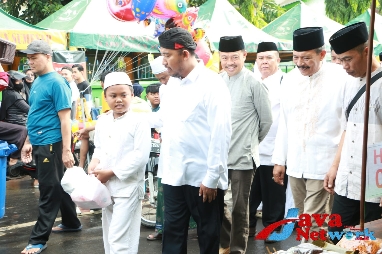 Bupati Achmad Fauzi Wongsojudo SH MH Saat Menemani Salah Satu Anak Yatim Untuk Berbelanja di Stand UMKM yang Telah Disediakan Panitia, Minggu (07/01/2023)