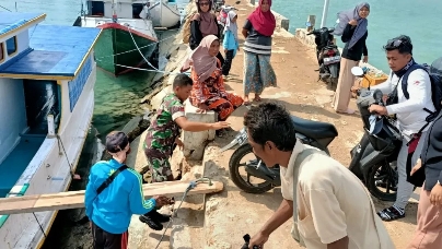 Ringankan Beban Warga, Babinsa Giligenteng Bantu Masyarakat Naikkan Motor Dari Perahu Ke Pelabuhan