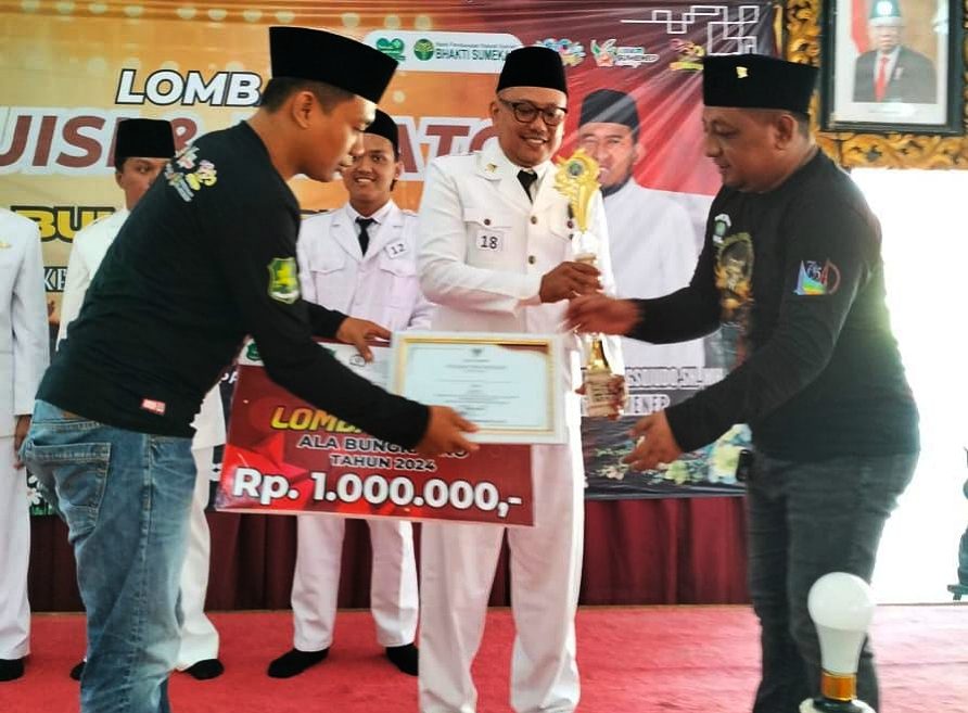 Ketua PD IWO Sumenep Imam Mustangin Saat Memberikan Hadiah kepada Juara I Delegasi BKPSDM Sumenep, Yohanes Iwan Hari Prasetyo