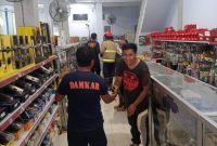 Tim Unit Reaksi Cepat Damkar Sumenep saat Akan Mengevakuasi Seekor Ular Di Toko Bangunan di Depan Kantor Dinkes P2KB Sumenep, Minggu (01/06/2025)