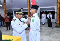 Bupati Sumenep Achmad Fauzi Wongsojudo menyematkan lencana dan memasangkan kendit secara simbolis kepada pemimpin upacara Ade Rehanza Andika Kurniawan.