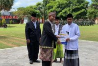 Bupati Sumenep Achmad Fauzi Wongsojudo Didampingi Karutan Sumenep Heri Sutriadi Saat Menyerahkan Surat Remisi Secara Simbolis kepada Warga Binaan Rutan Sumenep di Momentum Peringatan HUT RI ke-80 di Halaman Pemkab Sumenep, Minggu (17/08/2025)