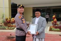 KHR. Achmad Qusyairi Zaini, pengasuh Pondok Pesantren Hidayul Ulum Utara Saat Menerima Penghargaan Dari Kapolres Sumenep AKBP Rivanda SIK di Halaman Polres Sumenep, Senin (20/10/2025)