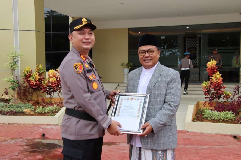 KHR. Achmad Qusyairi Zaini, pengasuh Pondok Pesantren Hidayul Ulum Utara Saat Menerima Penghargaan Dari Kapolres Sumenep AKBP Rivanda SIK di Halaman Polres Sumenep, Senin (20/10/2025)