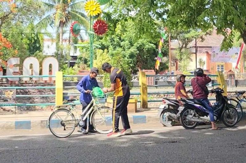 Relawan KBS Sumenep Saat Memberikan Nasi Bungturat Kepada Pengemudi Sepeda Ontel, Jum'at (31/10/2025)