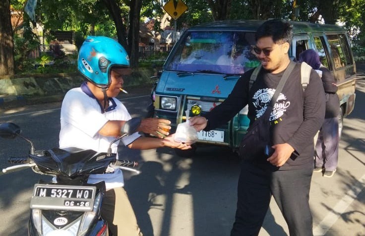 Suasana Di Saat KBS Sumenep Membagikan Nasi Bungturat Kepada Salah Satu Pengendara di Jalan Urip Sumoharjo, Jum'at (30/01/2025)