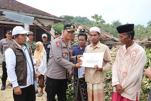 Kabag Ops Polres Sumenep, Kompol Junaidi, S.Pd., menyerahkan bantuan kemanusiaan kepada warga terdampak di Desa Karduluk, Kecamatan Pragaan.