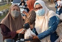 Ketua DPD KPPI Sumenep Yusnaniyah MPd Saat Memberikan Bungkusan kepada Warga 