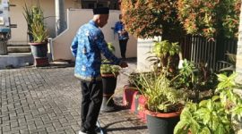 Asn BKAD Sumenep H. Suwarto Saat Melakukan Penyiraman Bunga di Taman Kantor BKAD Sumenep 